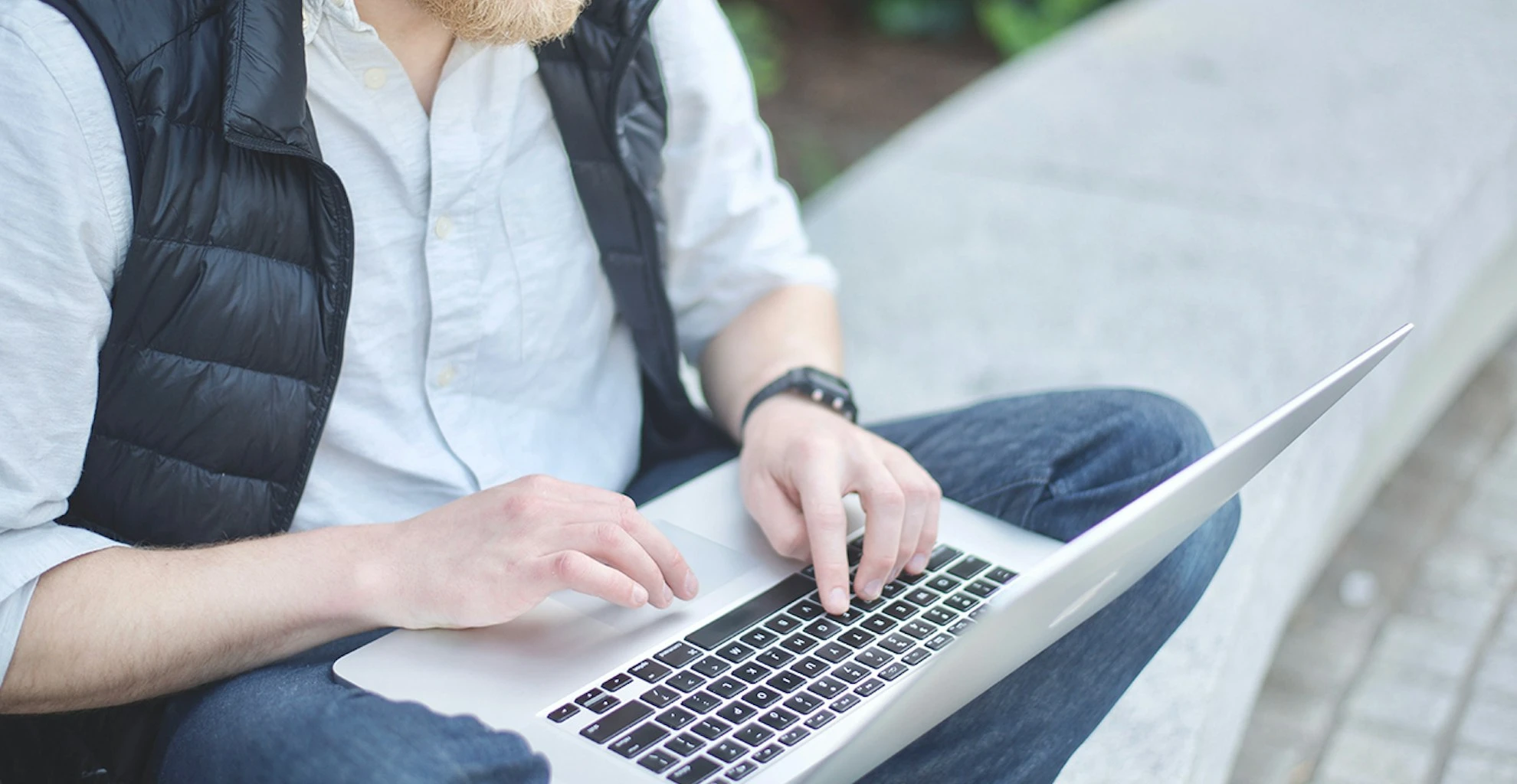 Man sitting outdoors using his laptop.
