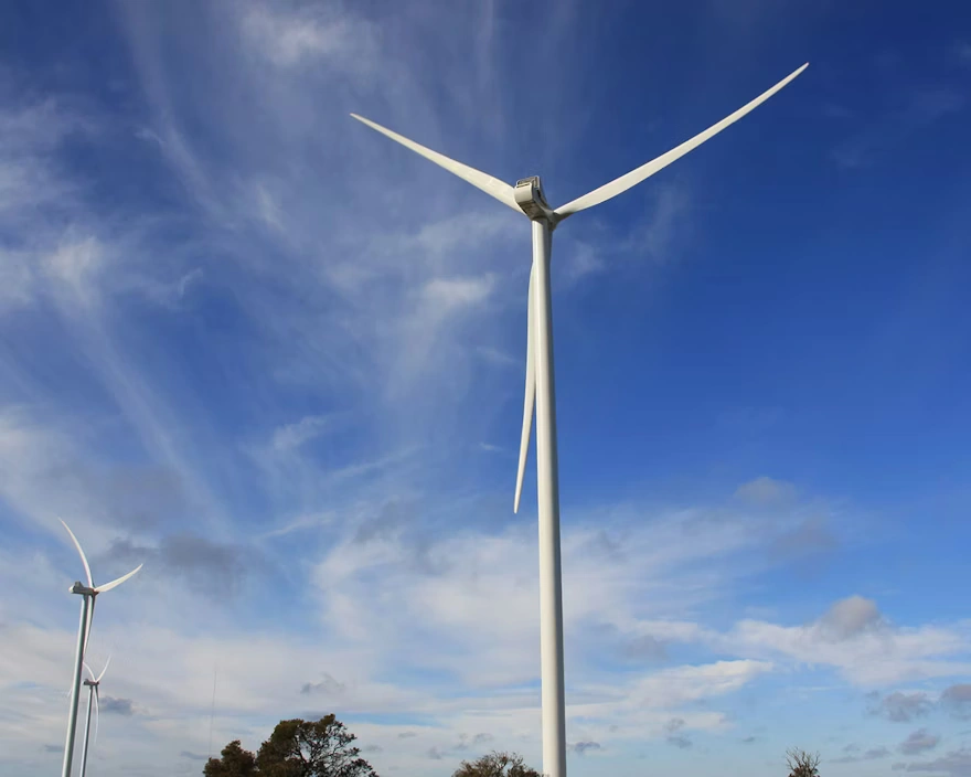 Wind-turbine-against-blue-cloud-sky_880x704.webp